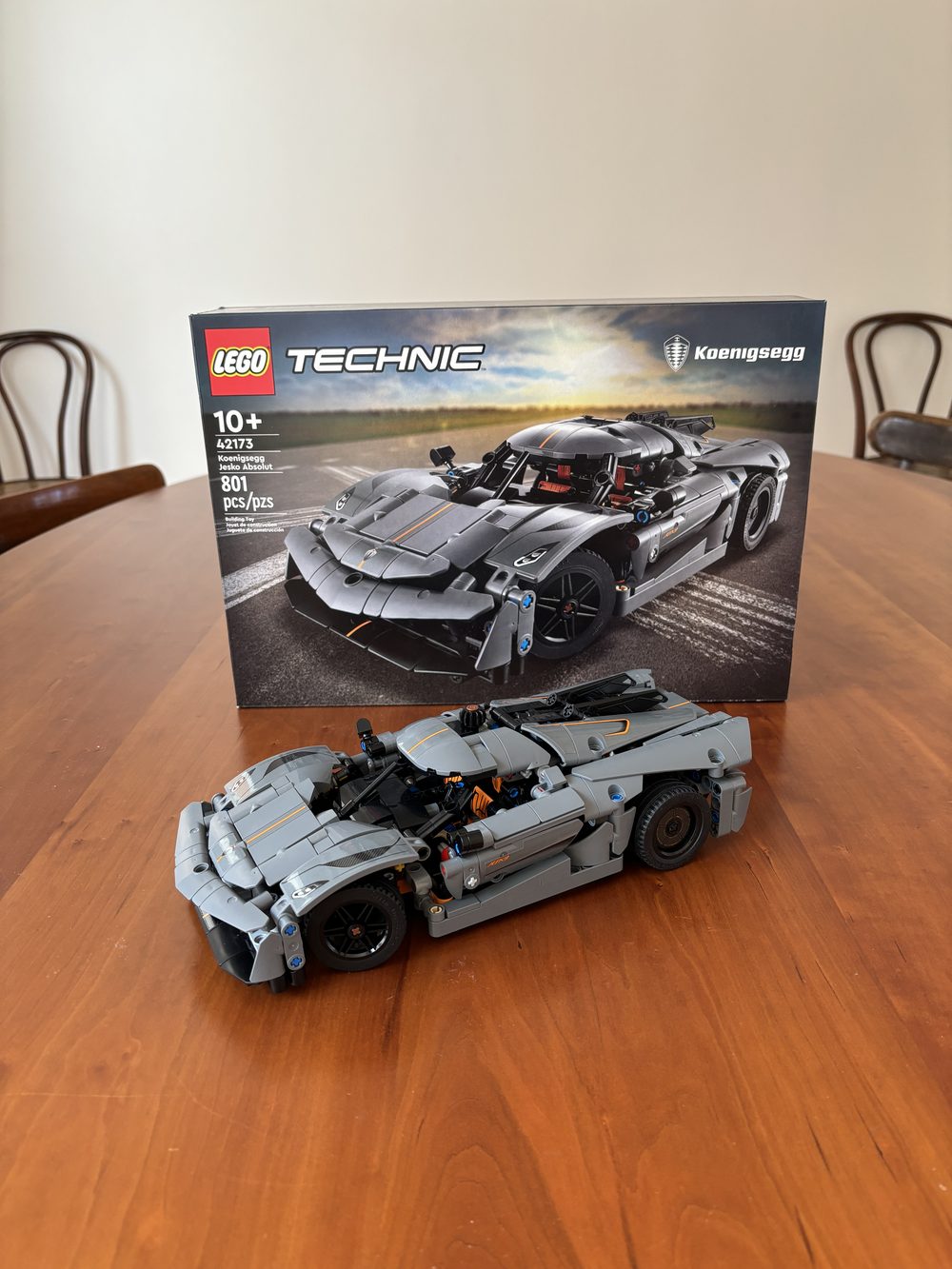 The finished grey Koenigsegg Jesko Absolut parked in front of its box.