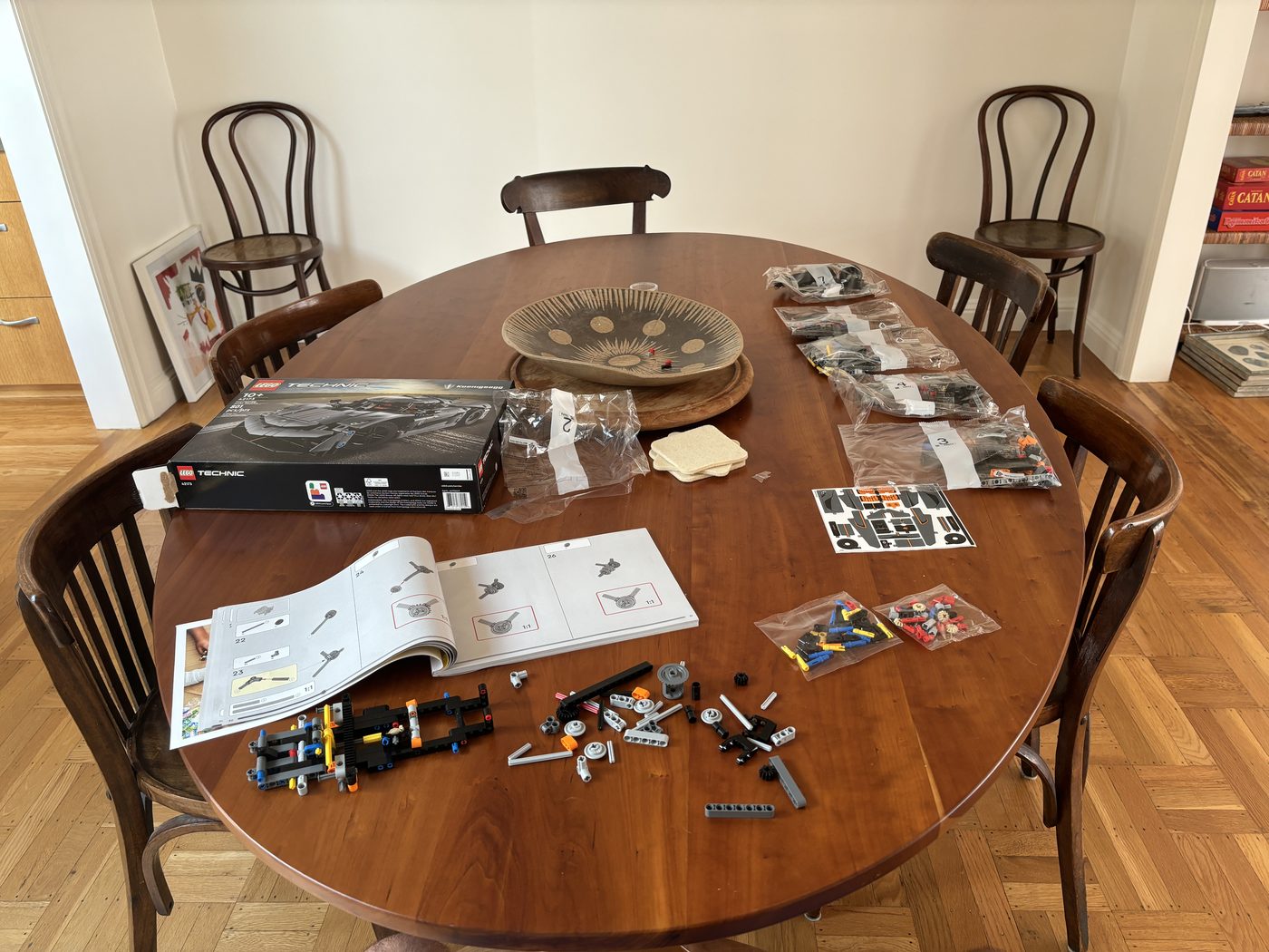 The Jesko mid-build on the dining table — numbered bags, instructions open, chassis started.