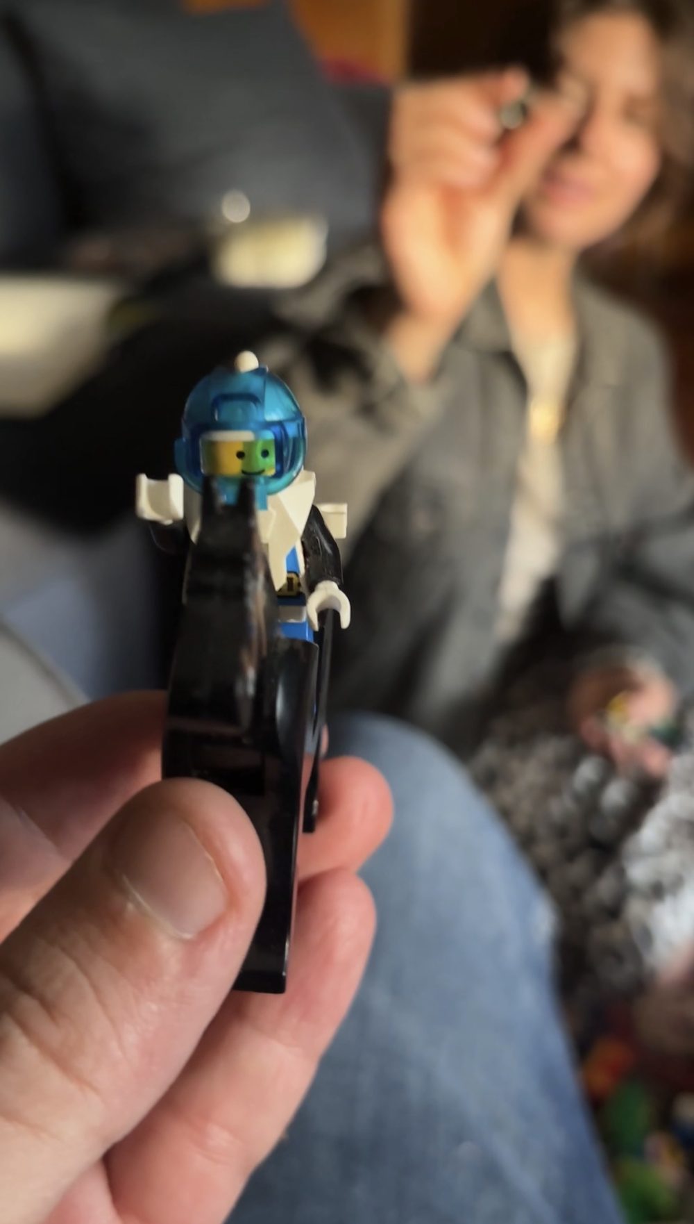 Holding up a space minifig with its blue helmet, mid-sorting session.